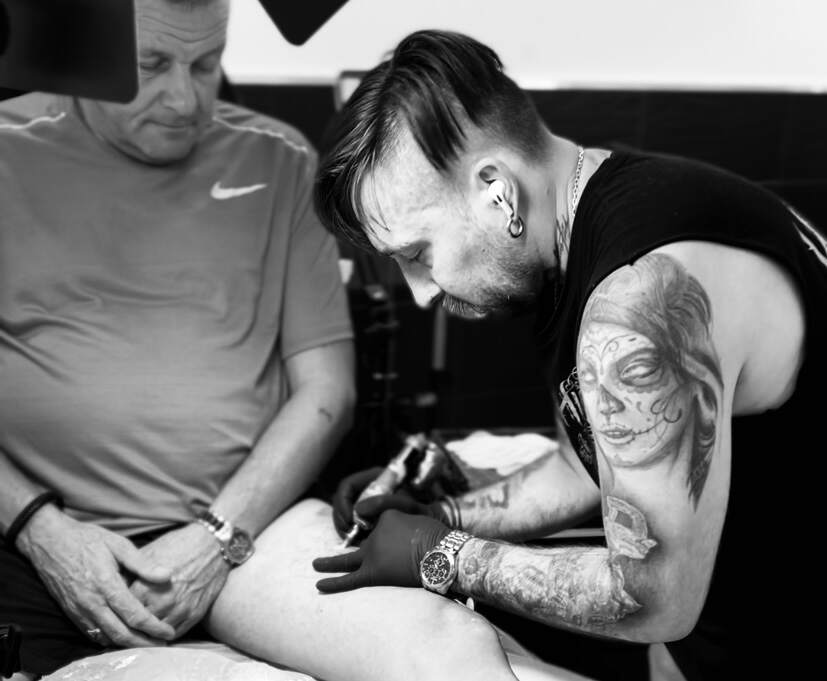 Onze artiest Alex is iemand aan het tatoeëren